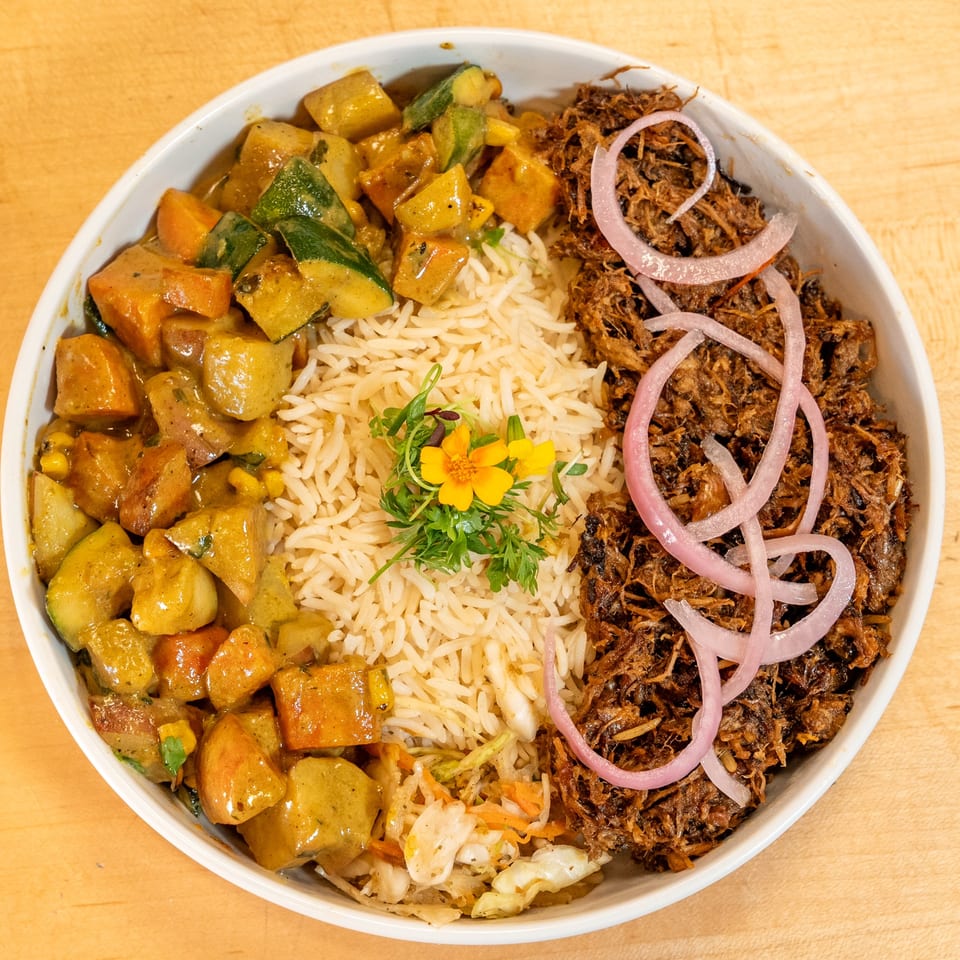 Manjay Restaurant's Caribbean bowl with curried vegetables, rice, pulled pork, and pickled onions.