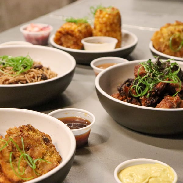 A variety of Caribbean dishes from Manjay Restaurant, including rice, meat, and fried plantains.